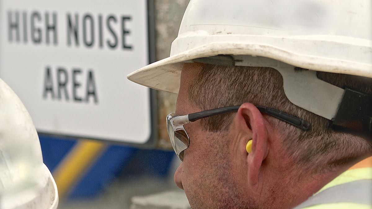Construction worker with hard hat, safety glasses, and ear plugs