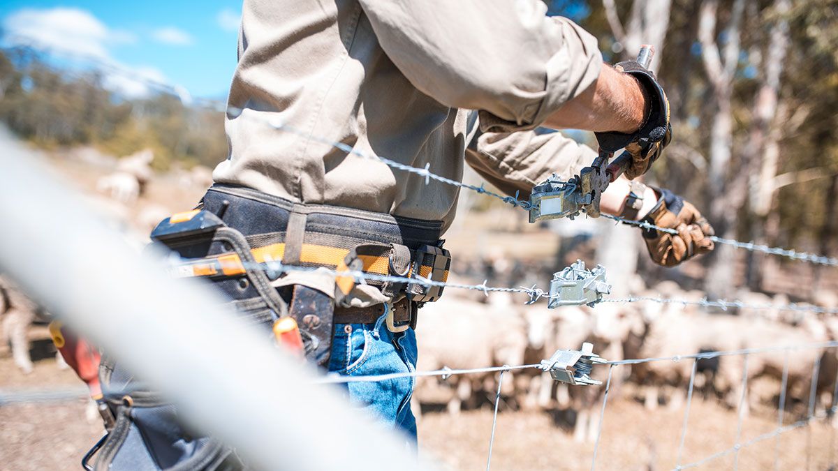 images/pages/news/must-have-tools-for-constructing-a-fence/man-with-tool-belt-constructing-fence-with-joiner.jpg