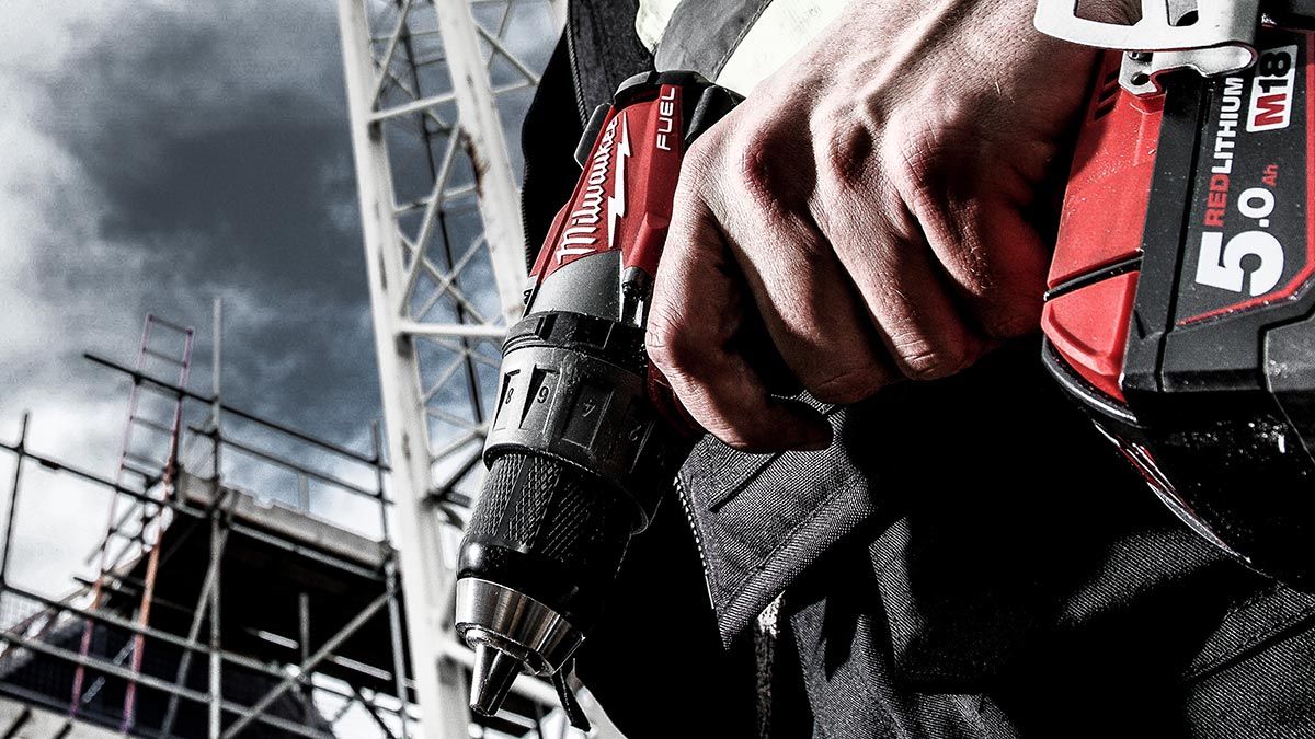 Tradesman holding a power drill by his side