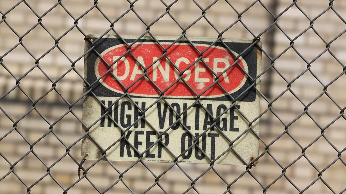 High Voltage sign behind chain mesh fencing