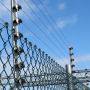 A view looking up at electric security fencing infrastructure