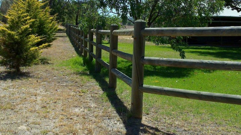 A wooden fence constructed from copper logs